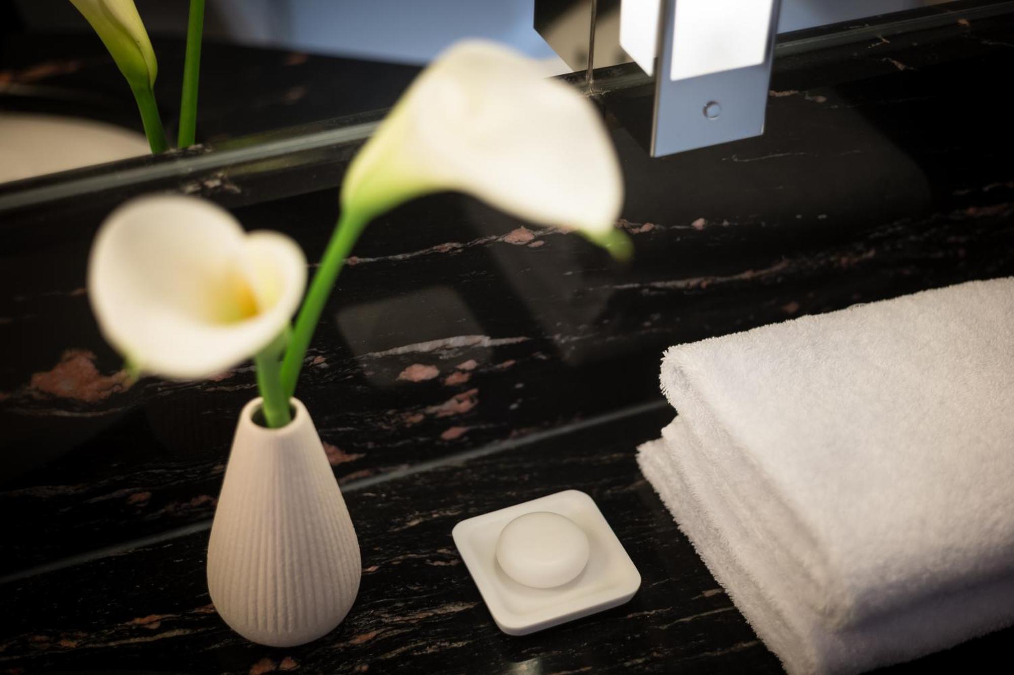 GRAND ELYSEE Hamburg Bagian luar foto A small vase of flowers in a hotel room